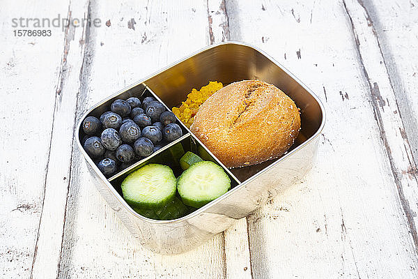 Lunchpaket mit Gurkenscheiben  Blaubeeren und Brötchen mit Linsenpaste
