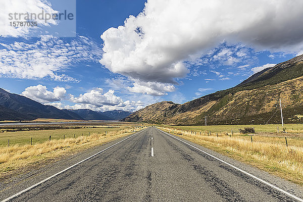 Neuseeland  Grey District  Inchbonnie  Wolken über dem leeren State Highway 73 mit Bergen im Hintergrund