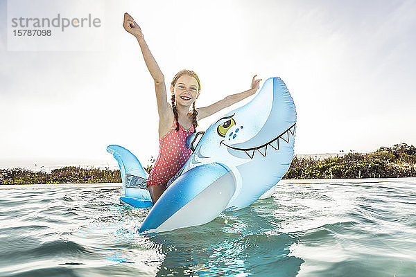 Portrait von Happygirl im Schwimmbad mit aufblasbarem Haifischbeckenspielzeug