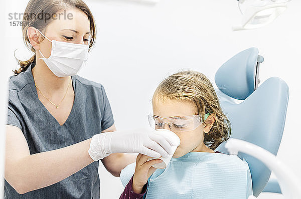 Mädchen beim Zahnarzt  das sich den Mund wäscht