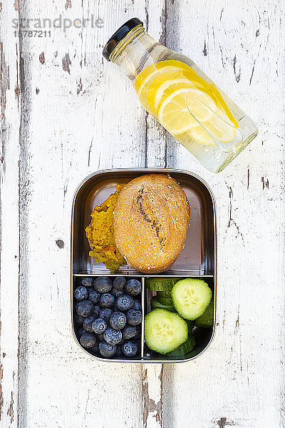 Limonadenflasche und Lunchbox mit Gurkenscheiben  Blaubeeren und Brötchen mit Linsenpaste