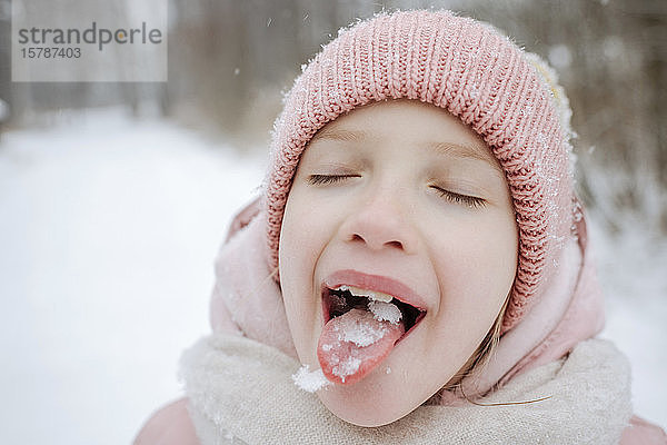 Porträt eines Mädchens mit geschlossenen Augen  das Schnee schmeckt