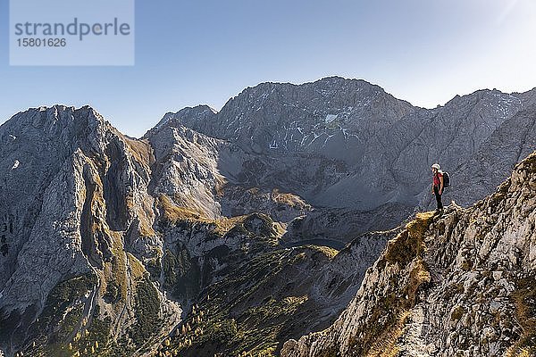 Bergsteiger mit Kletterhelm steht auf einem Felsvorsprung  Wanderweg zur Ehrwalder Sonnenspitze  Ehrwald  Mieminger Kette  Tirol  Österreich  Europa