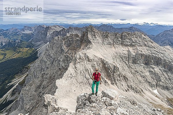 Frau steht auf Felsen und schaut in die Kamera  Blick von der Birkkarspitze  Karwendeltal  Tirol  Österreich  Europa