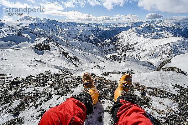 Blick vom Gipfel der Geierspitze  Beine mit Skischuhen vor verschneitem Bergpanorama  Wattentaler Lizum  Tuxer Alpen  Tirol  Österreich  Europa