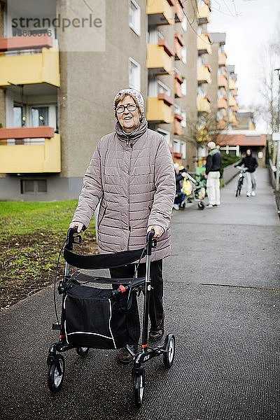 Seniorin mit Rollator vor einem Wohnhaus für Senioren  Köln  Nordrhein-Westfalen  Deutschland  Europa