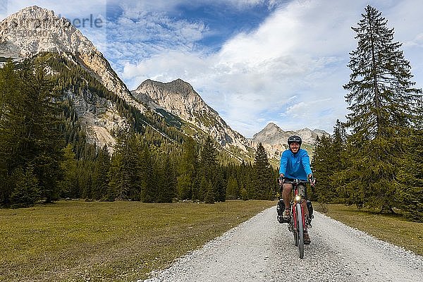 Radfahrer  Mountainbiker fährt auf Schotterstraße  Karwendeltal  Weg zum Karwendelhaus  Tirol  Österreich  Europa