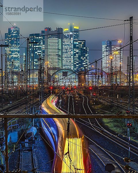 Fahrender Zug vor dem Hauptbahnhof Frankfurt am Main vor der Skyline  bunt beleuchtet  Frankfurt  Hessen  Deutschland  Europa