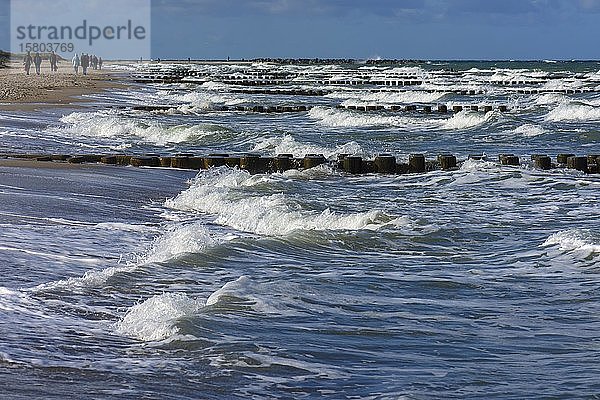 Spaziergänger am Strand der Ostsee mit Wellen  stürmisches Wetter  Darß  Mecklenburg-Vorpommern  Deutschland  Europa
