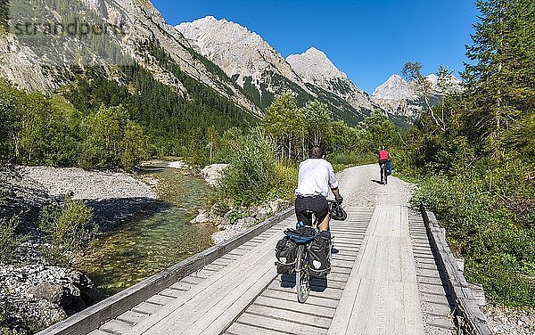 Radfahrer  Mountainbiker radeln auf Brücke über Bergbach  Schotterweg zum Karwendelhaus  Karwendeltal  Tirol  Österreich  Europa