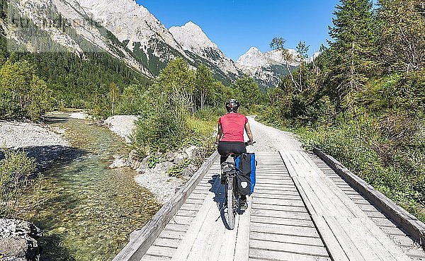 Radfahrer  Mountainbiker radelt auf Brücke über Gebirgsbach  Schotterweg zum Karwendelhaus  Karwendeltal  Tirol  Österreich  Europa