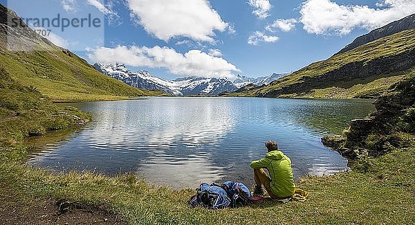 Wanderer mit Rucksack am Bachalpsee  Gipfel Schreckhorn und Finsteraarhorn  Grindelwald  Berner Oberland  Schweiz  Europa