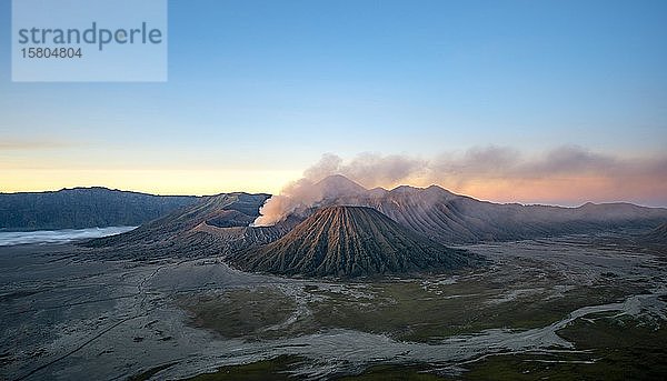 Vulkanlandschaft bei Sonnenaufgang  rauchender Vulkan Gunung Bromo  mit Mt. Batok  Mt. Kursi  Mt. Gunung Semeru  Bromo-Tengger-Semeru National Park  Java  Indonesien  Asien