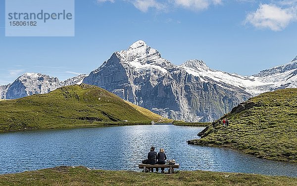 Wanderer rastend auf einer Bank  Bachalpsee mit Gipfel Wetterhorn  Grindelwald  Berner Oberland  Schweiz  Europa