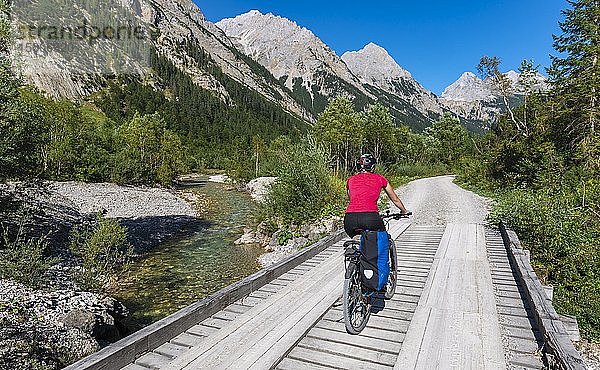 Radfahrer  Mountainbiker radelt auf Brücke über Gebirgsbach  Schotterweg zum Karwendelhaus  Karwendeltal  Tirol  Österreich  Europa