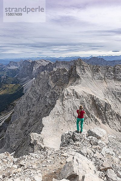 Frau auf Felsen stehend und fotografiert  Blick von der Birkkarspitze  Karwendeltal  Tirol  Österreich  Europa