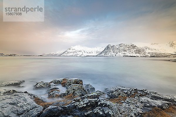 Küste von Gimsøy vor schneebedeckten Bergen  bei Gimsoykirke  Gimsoy  Lofoten  Norwegen  Europa