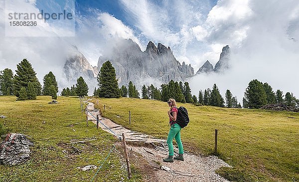 Junge Frau  Wanderin auf einem Wanderweg  im Rücken Sass Rigais  Parco Naturale Puez Odle  Südtirol  Italien  Europa