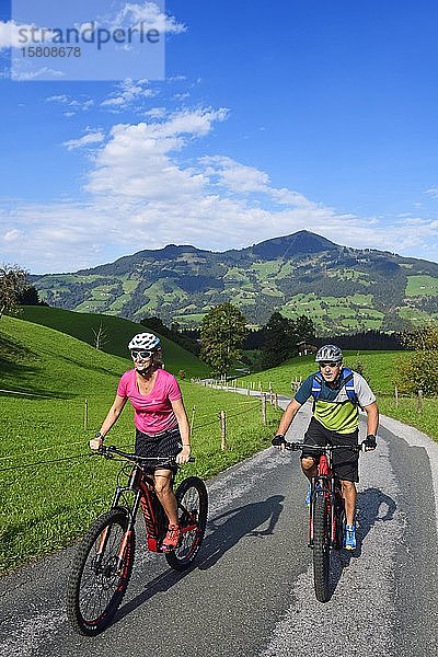 Zwei Radfahrer mit Elektro-Mountainbikes auf dem Glantersberg mit Blick auf die Hohe Salve  Kitzbüheler Alpen  Tirol  Österreich  Europa