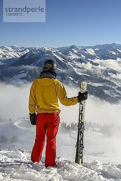 Skifahrer an der Skipiste stehend mit Ski  Blick in die Ferne  verschneites Bergpanorama  Gipfel Hohe Salve  SkiWelt Wilder Kaiser Brixenthal  Hochbrixen  Tirol  Österreich  Europa