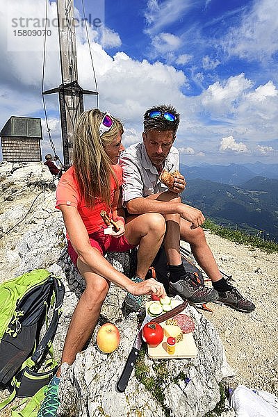 Wanderer bei einer Brotzeit auf dem Gipfel des Geigelsteins  Sachrang  Chiemgau  Oberbayern  Bayern  Deutschland  Europa