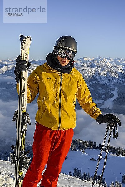 Skifahrer auf der Skipiste stehend  Ski haltend  in die Kamera schauend  Gipfel Hohe Salve  SkiWelt Wilder Kaiser Brixenthal  Hochbrixen  Tirol  Österreich  Europa
