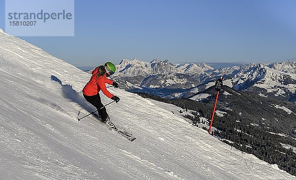 Skifahrer fährt steilen Hang hinunter  schwarze Piste  blauer Himmel  Berge im Hintergrund  SkiWelt Wilder Kaiser  Brixen im Thale  Tirol  Österreich  Europa