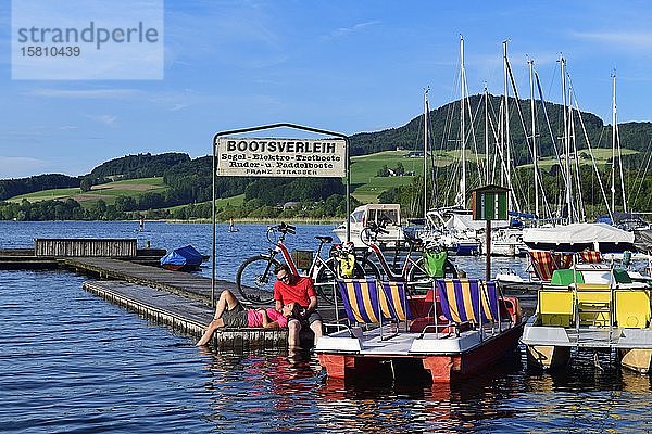 Pärchen mit Elektrofahrrädern pausiert an einem Steg am Obertrumer See  Obertrum  Salzburger Seenland  Salzburger Land  Österreich  Europa