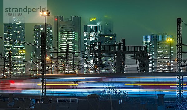 Fahrender Zug vor der Skyline am Abend  bunt beleuchtet  Hauptbahnhof  Frankfurt  Hessen  Deutschland  Europa