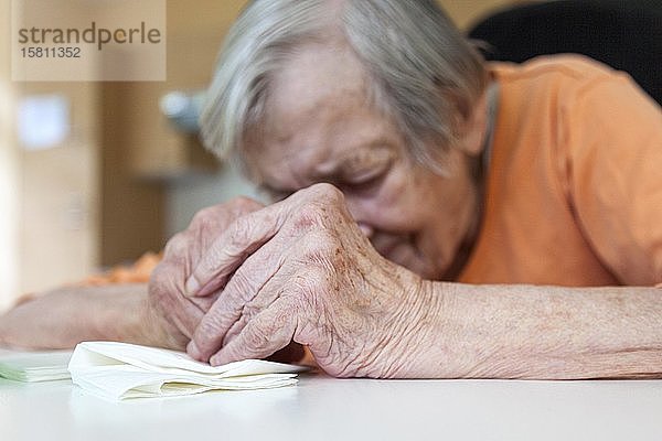 Alte  traurige Frau über den Tisch gebeugt  Berlin  Deutschland  Europa