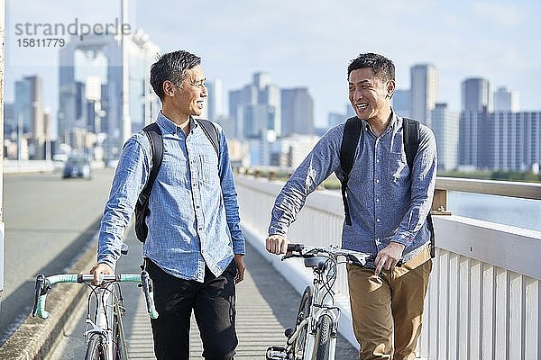 Ältere japanische Männer mit Fahrrädern in der Innenstadt von Osaka  Japan