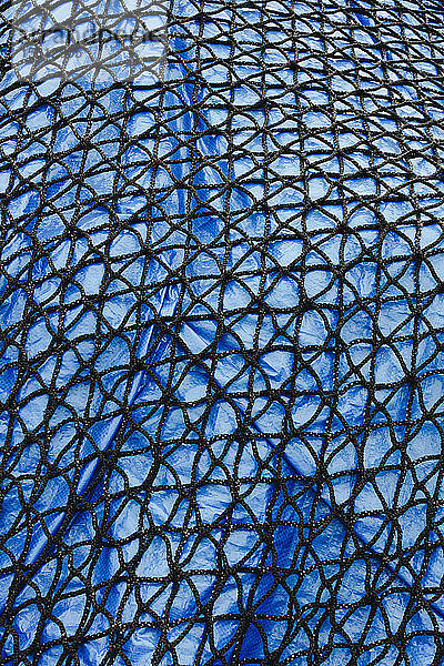 Detail eines kommerziellen Fischernetzes mit blauer Plane