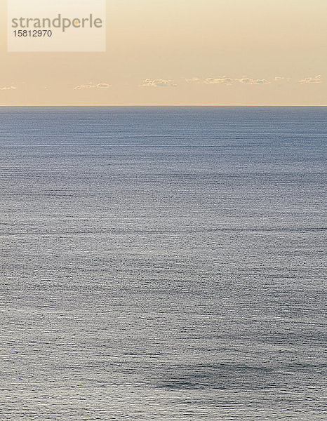 Blick auf ruhiges Ozeanwasser  Horizont und Himmel in der Morgendämmerung