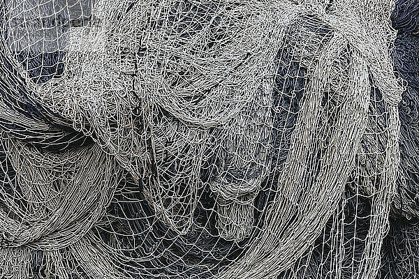 Stapel kommerzieller Fischernetze und Kiemennetze auf einem Fischereikai.
