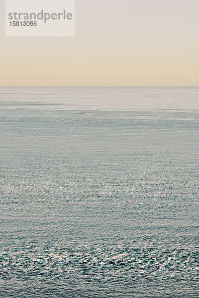 Blick auf ruhiges Ozeanwasser  Horizont und Himmel in der Morgendämmerung