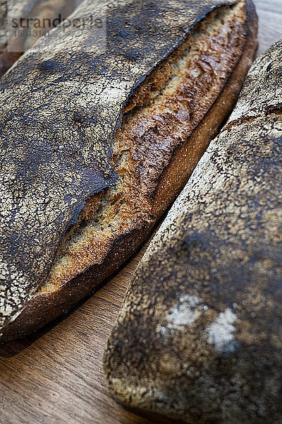 Nahaufnahme mit hohem Winkel von zwei frisch gebackenen Brotlaiben in einer handwerklichen Bäckerei.