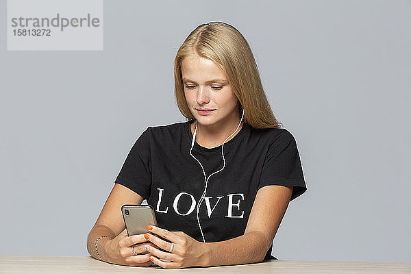 Junge Frau im verliebten T-Shirt beim Musikhören mit mp3-Player und Kopfhörern