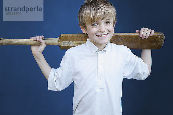 Portrait lächelnder Junge mit Kricketschläger
