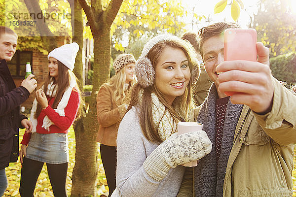 Glückliches Teenager-Paar macht Selfie mit Smartphone im Herbstpark