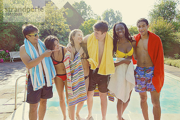 Porträt glückliche Teenager-Freunde am sonnigen Sommerpool