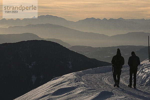 Silhouettierte Menschen beim Wandern auf einem verschneiten Berg  Brixen  Südtirol  Italien