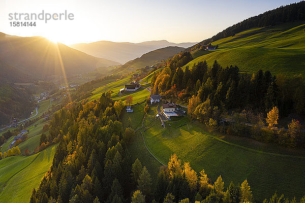 Sonnenstrahl bei Sonnenuntergang beleuchtet die warmen Farben des Herbstes im Fünser Tal  Luftaufnahme  Dolomiten  Provinz Bozen  Südtirol  Italien  Europa