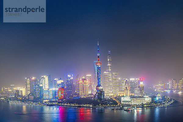 Die beleuchtete Skyline des Bezirks Pudong in Shanghai mit dem Huangpu-Fluss im Vordergrund  Shanghai  China  Asien