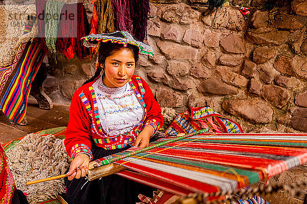 Quechua-Frau aus den Gemeinschaften Accha Huata  Bombom und Paucartambo bei der Arbeit an ihrem Webstuhl  Heiliges Tal  Peru  Südamerika