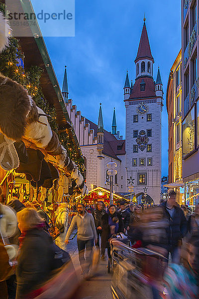 Blick auf das Alte Rathaus und den belebten Weihnachtsmarkt auf dem Marienplatz in der Abenddämmerung  München  Bayern  Deutschland  Europa