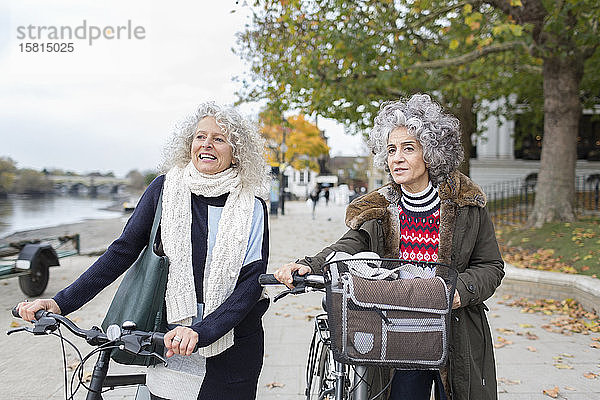 Aktive Seniorinnen  die mit dem Fahrrad im Herbstpark unterwegs sind