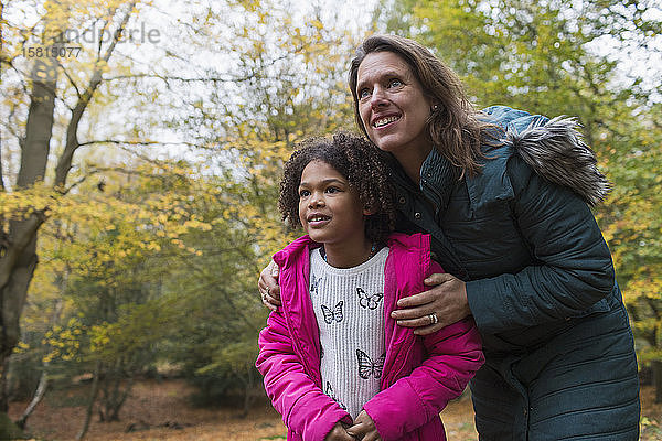 Neugierige Mutter und Tochter im Herbstwald