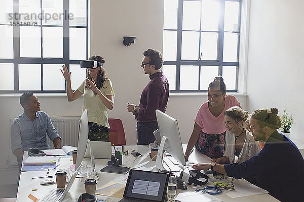 Computerprogrammierer beim Programmieren einer Virtual-Reality-Simulator-Brille in einem Großraumbüro