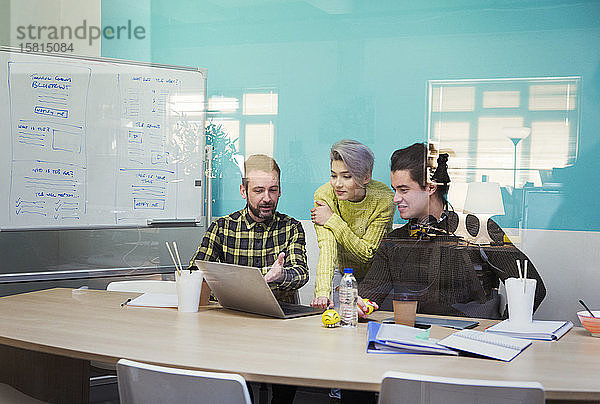 Geschäftsleute arbeiten an einem Laptop in einem Konferenzraum