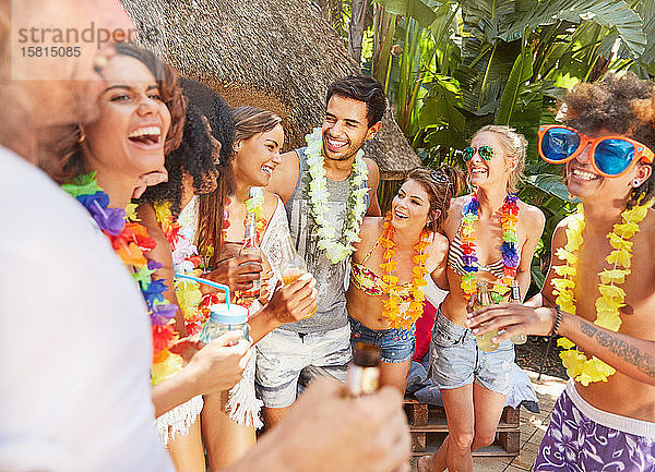 Junge Freunde mit Blumenkränzen  die im Sommer am Pool abhängen